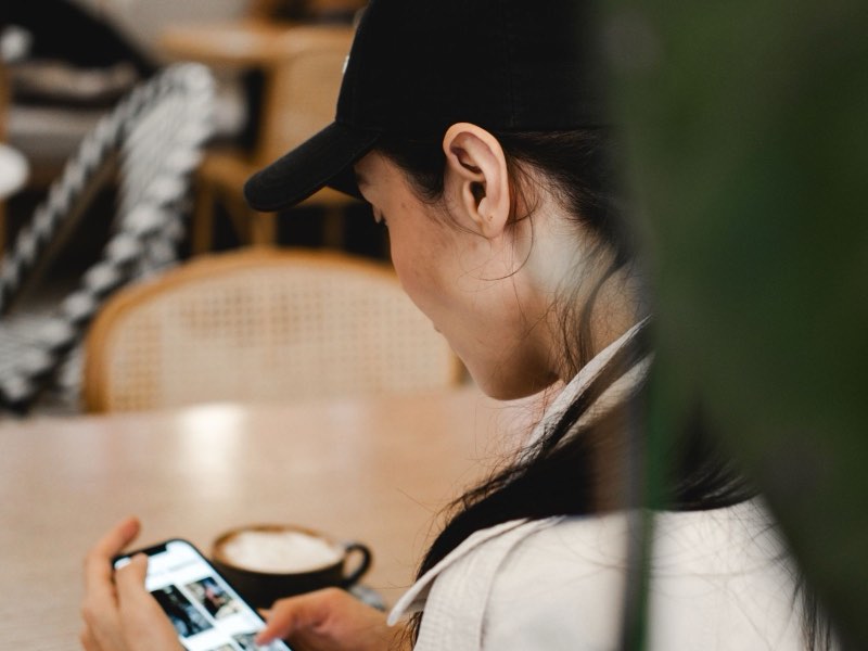 Cliente usando o celular à mesa de um café